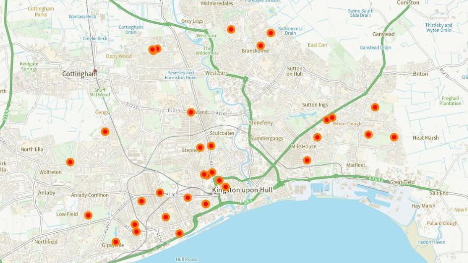 A map of the city of Hull showing the location of warm spaces, which are represented by orange dots. Built-up areas are shaded light grey, with the names of suburbs labelled. Main arterial roads are shown in green, railways in dark grey and rivers and docks in blue.