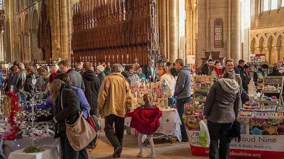 Pic of the Christmas Market from last year - with people shopping around stalls of items inside the historic Cathedral.