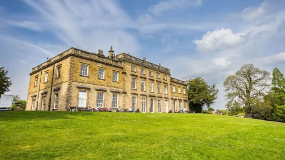 A large stone-built house surrounded by grass and trees. It is Cannon Hall Museum, Barnsley
