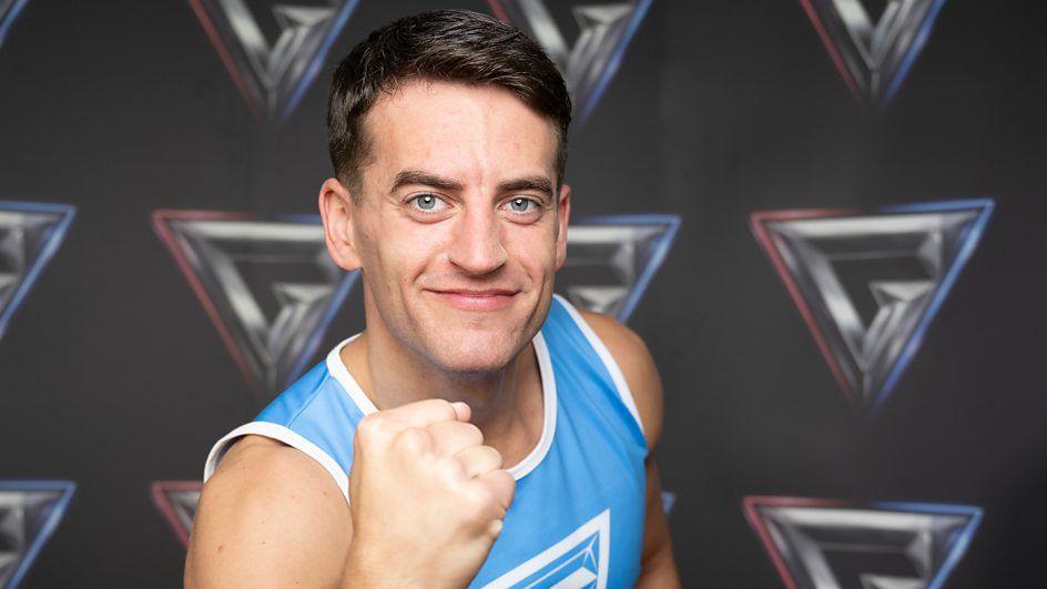 josh macdonald raising a fist to camera in a blue kit.