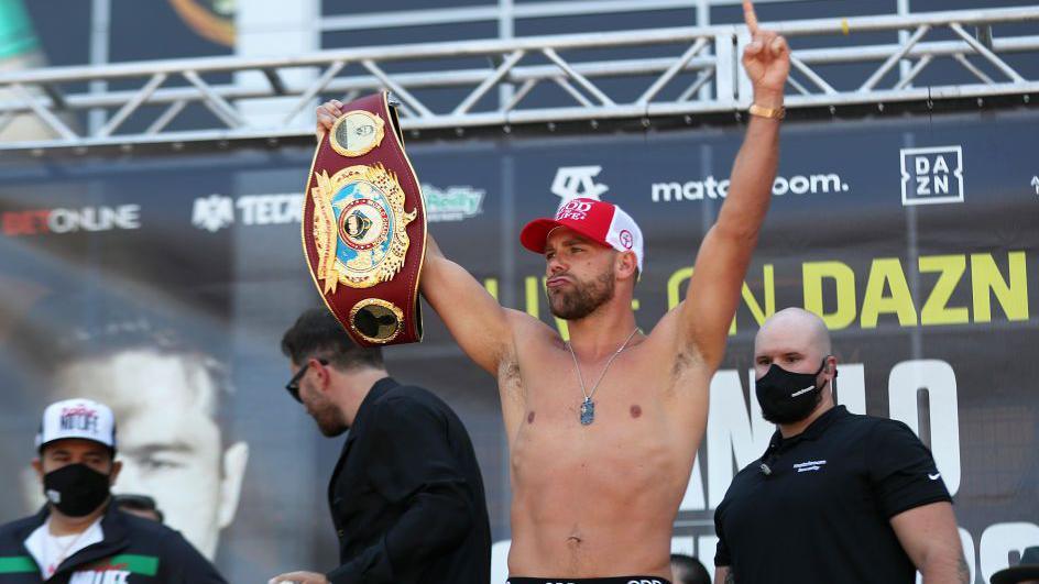 Boxer Billy Joe Saunders poses for picture with his championship belt during the weigh in for his fight against Canelo Alvarez in 2021