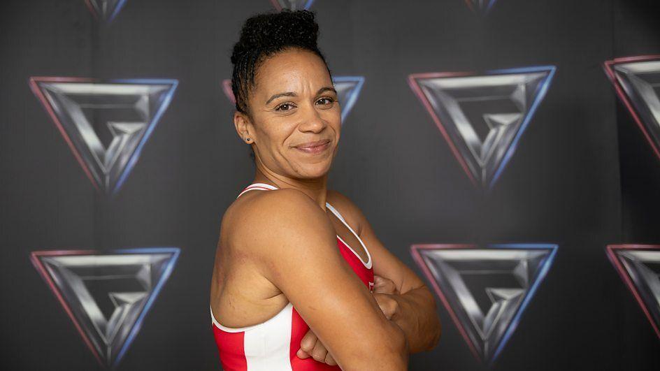 naomi church crossing her arms in a red kit.