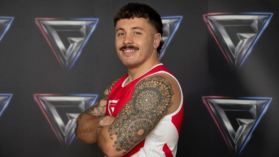 tyler spence crossing his arms in a red kit.