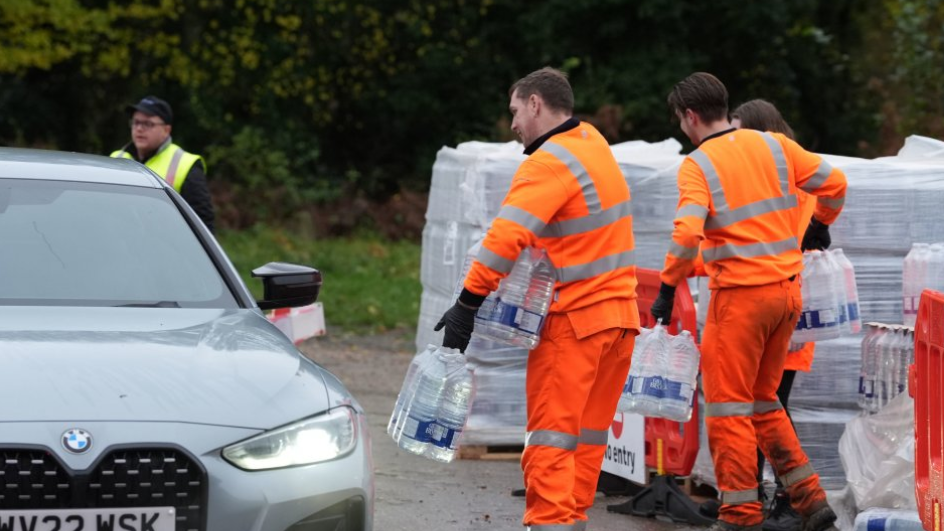 Men holding packs of water bottles