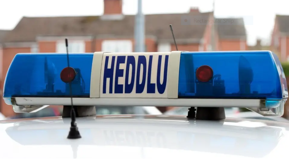 Arwydd heddlu ar do cerbyd heddlu