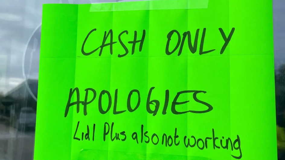 A bright green sign in a window saying "Cash only. Apologies"