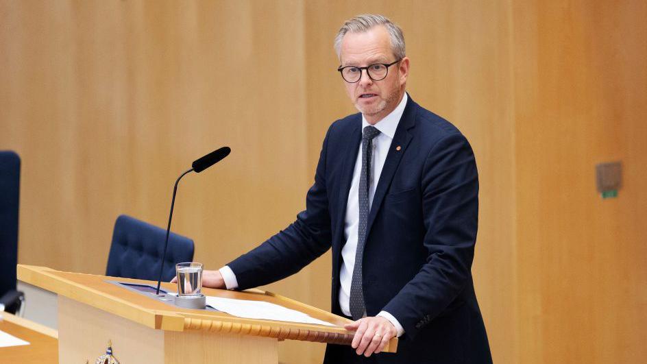 Mikael Damberg, a Swedish politician in a suit, speaks at a lectern