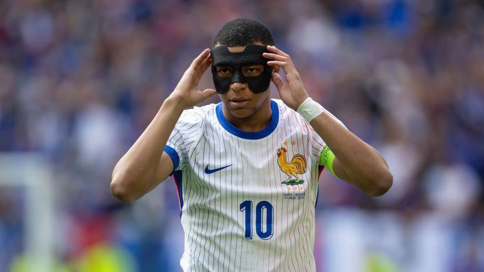 Kylian Mbappe adjusting his mask during a Euros game