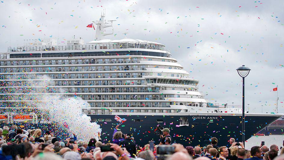 Members of the public attend the naming ceremony at Liverpool Pier Head for Cunard's Queen Anne with confetti being thrown and people flying Union Jack flags to celebrate.
