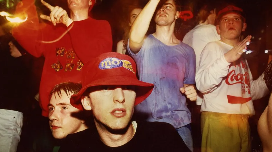 A group of ravers dancing at The Eclipse club in Coventry. They are wearing an array of bright clothes and a range of hats 