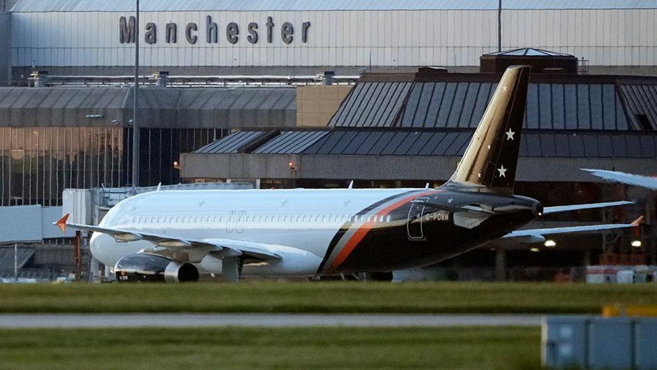 General view of an aircraft at Manchester Airport outside the grey terminal