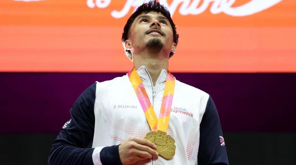 Jake, a man wearing a white zipped jacket, wearing a gold medal around his neck.