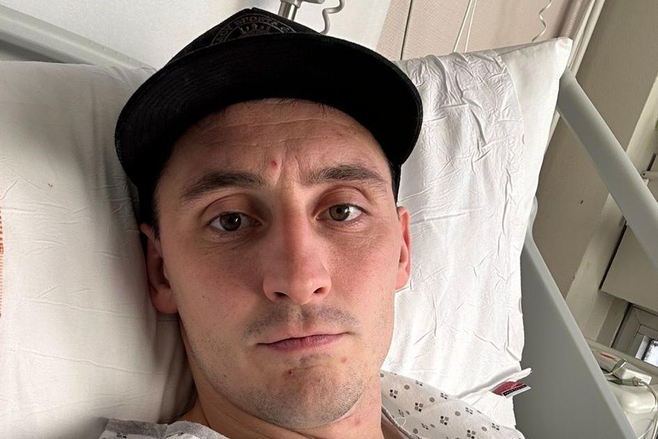 Sam Davies yn gorwedd ar wely ysbyty