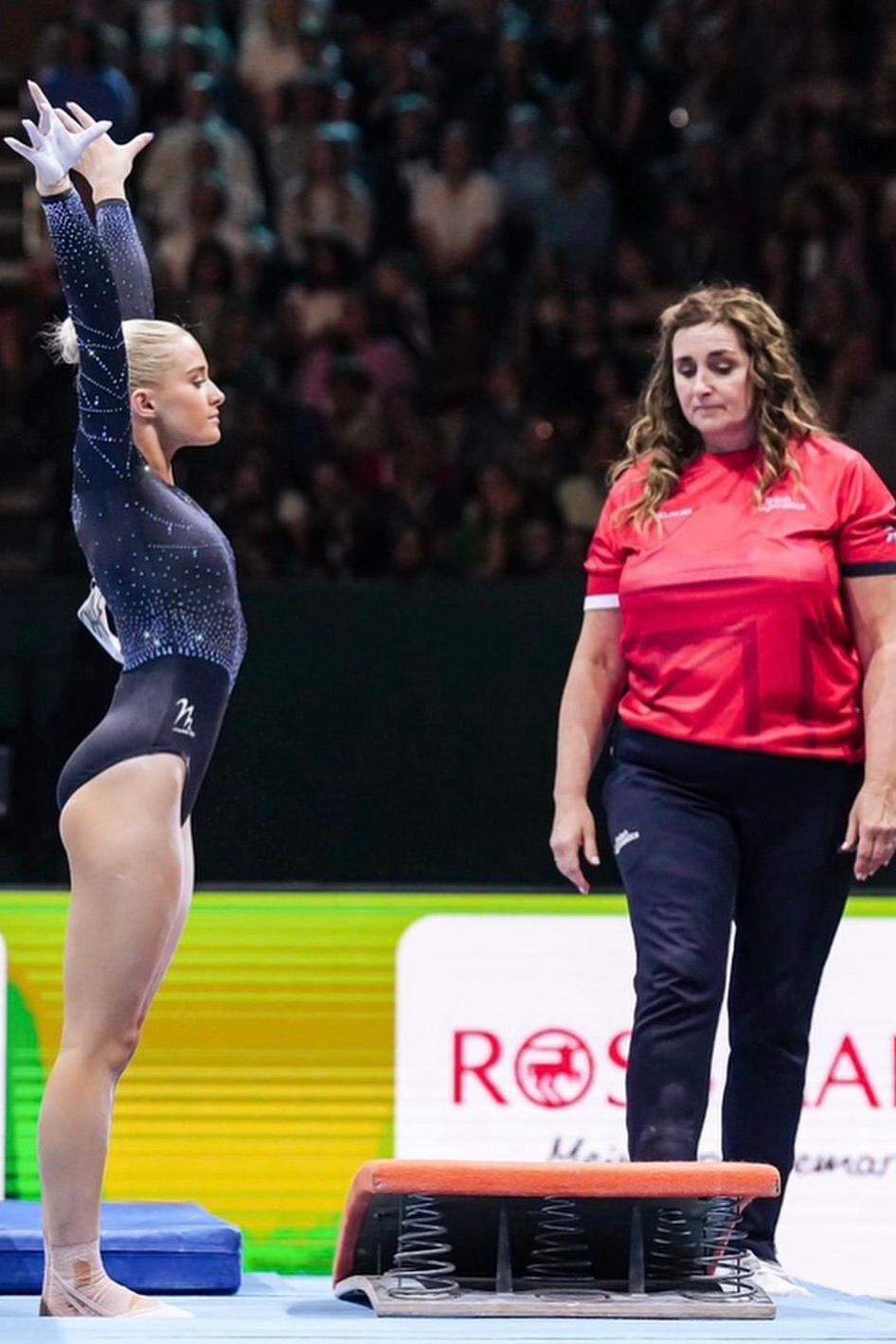 Rugby Evans is on the left, wearing a blue leotard with her arms in the air. On the right, Tracey Skirton-Davies wears a red top and blue trousers