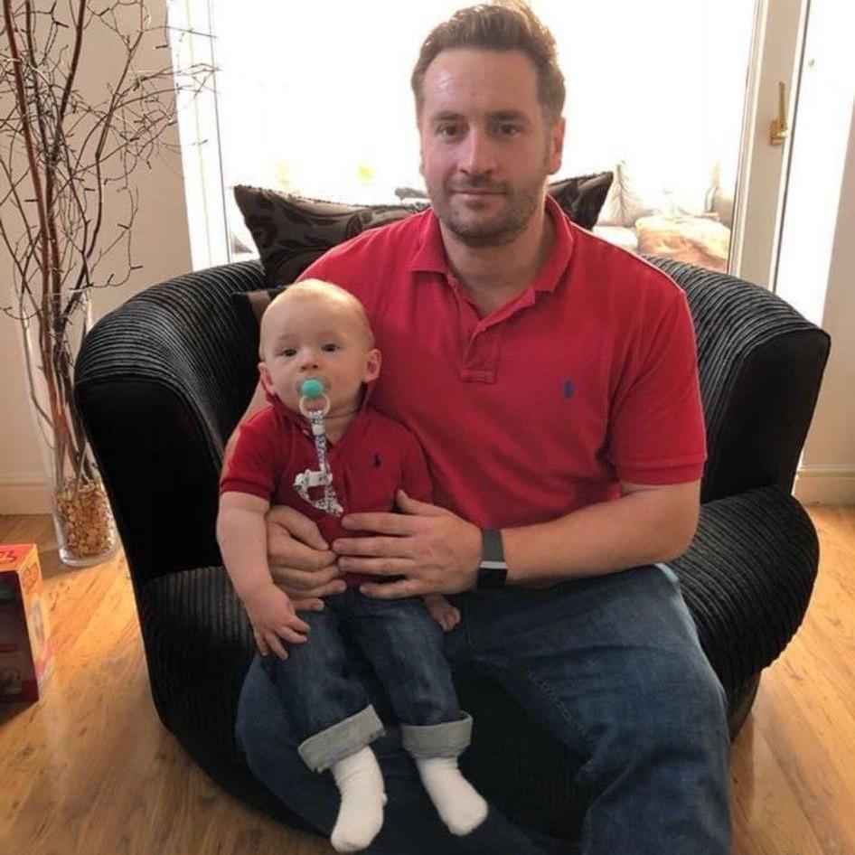 Gavin is sat with Fletcher on his knee, before he was admitted to the hospice.