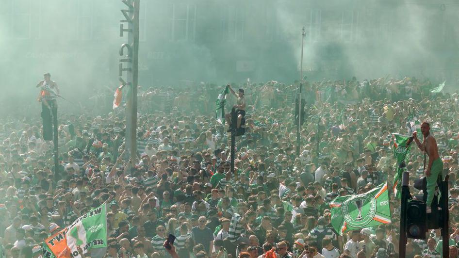 Thousands of fans gathering in the Trongate area of Glasgow with some visible standing aloft traffic lights