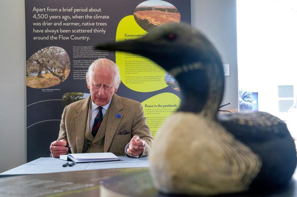 King Charles signing the visitor book at RSPB Scotland's centre at Forsinard