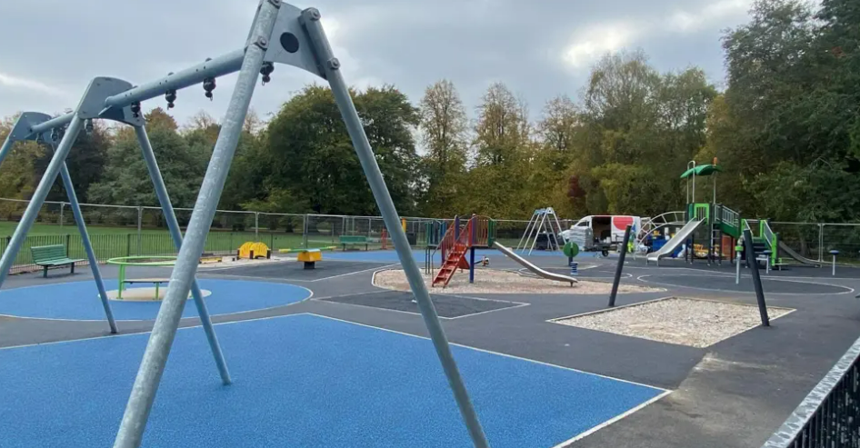 A playground at Calderstones Park in south Liverpool. There are swings, roundabouts, a slide and climbing frames.