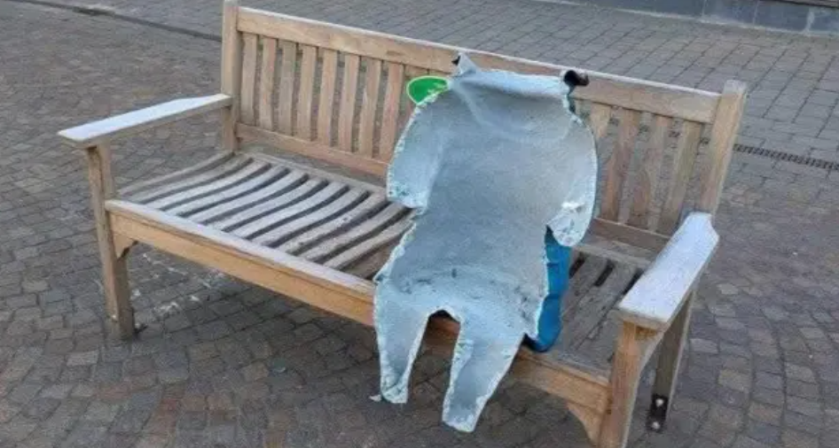 The damaged statue of Paddington on its bench. Only part of it is left, with the front completely torn off.