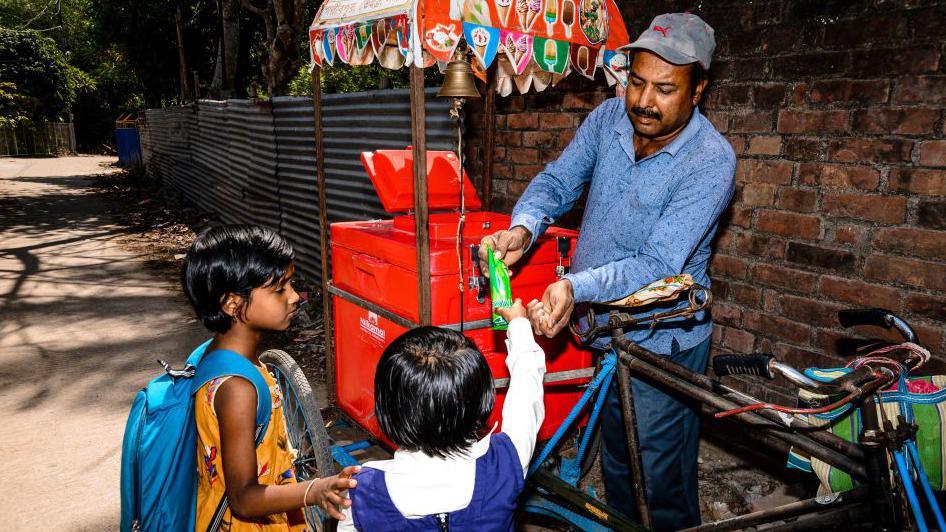 Children buying ice cream from a cart on a hot afternoon in Tehatta, West Bengal, India