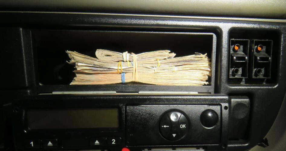 A photo of a stack of bank notes in a panel above a radio, seized during the people smuggling operation allegedly linked to Goran Jalal.