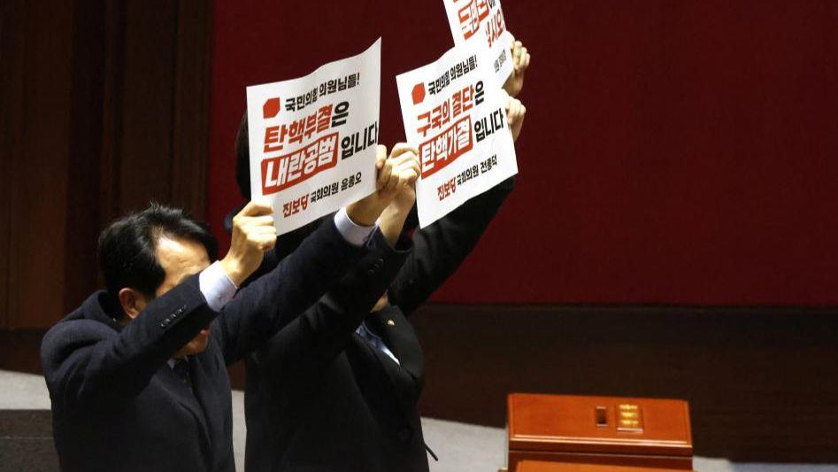 Lawmakers of the main opposition Democratic Party hold up placards calling for the impeachment of President Yoon Suk Yeol