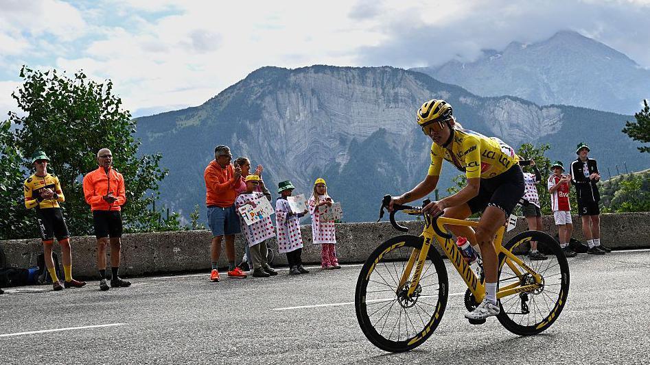 Kasia Niewiadoma rides up Alpe d'Huez in the yellow jersey at last year's Tour de France as fans watch on from the side of the road
