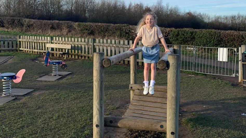 Elemie Rose Wainwright playing on a wooden climbing frame at Plumley Park in Sheffield