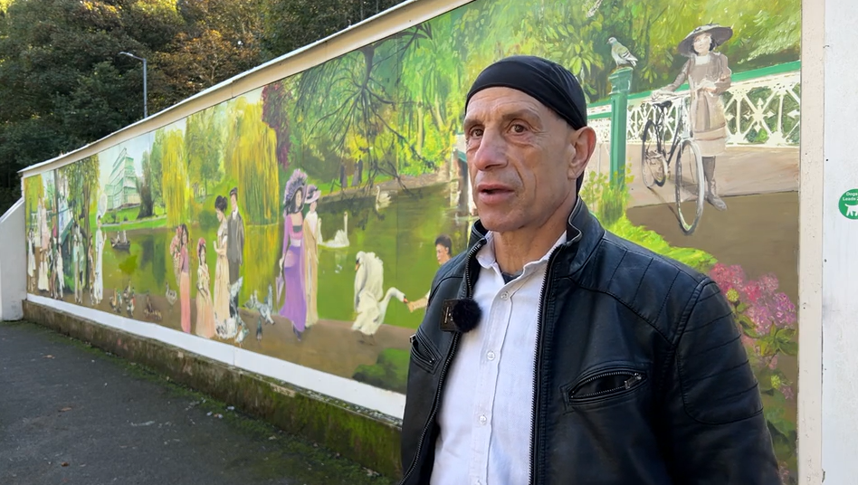 Robert Newbiggin stands in front of the mural he painted in Southport's Botanic Gardens