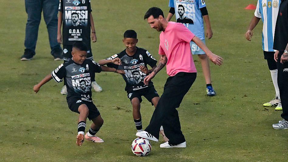 Lionel Messi plays football with children during a coaching clinic at Arun Jaitley Cricket Stadium