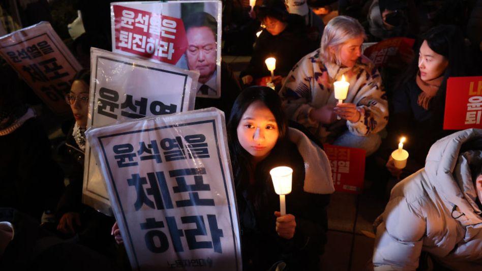 Protester with candle and sign at Seoul on Wednesday night