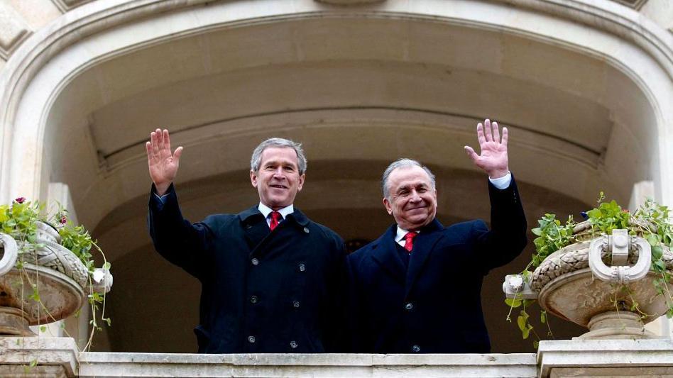 US President George W. Bush (L) waves with Romania's President Ion Iliescu (L) prior to a bilateral meeting at Cotroceni Palace 23 November 2002 in Bucharest, Romania