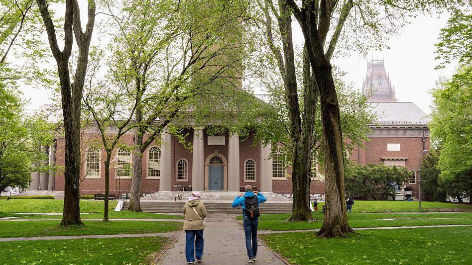 An exterior view of a building at Harvard University with people walking