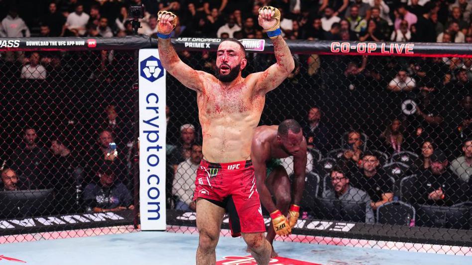 Belal Muhammad is bloodied by raises his arms in victory