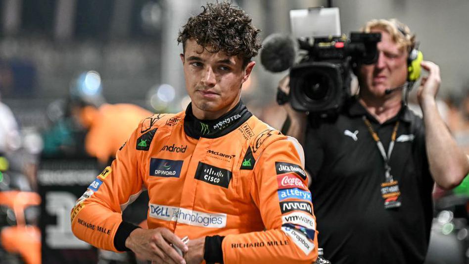 Lando Norris after getting out of the car and taking his helmet off after taking pole position for the Singapore Grand Prix