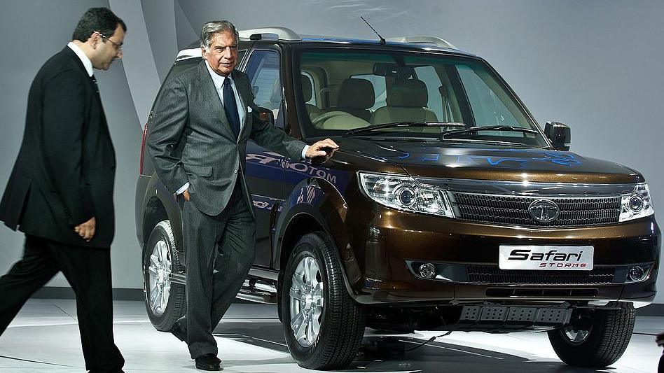Tata Group chairman Ratan Tata (R) looks on as Cyrus Mistry (L) walks past at the 2012 India Auto Expo in New Delhi on January 5, 2012. Behind them is a showroom model of the Tata Safari car.