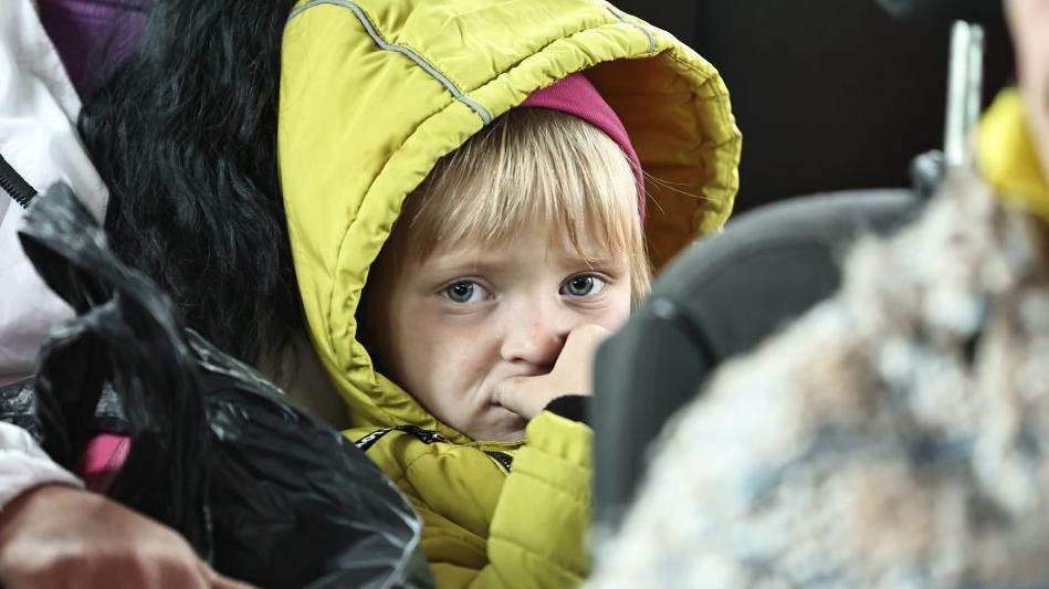  A woman and her daughter evacuated from a northern border settlement of Kharkiv Oblast wait in an evacuation bus for departure to Kharkiv city