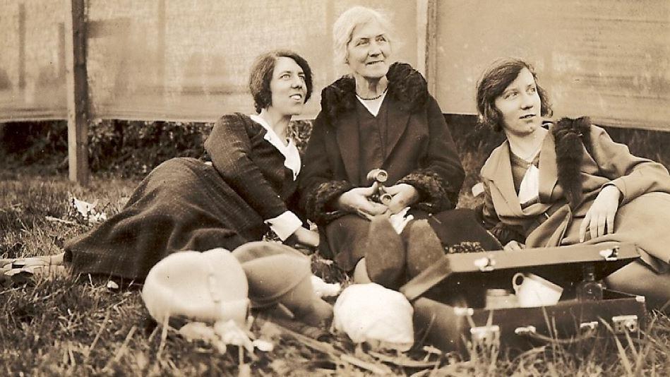 Three women sitting or lying on the ground