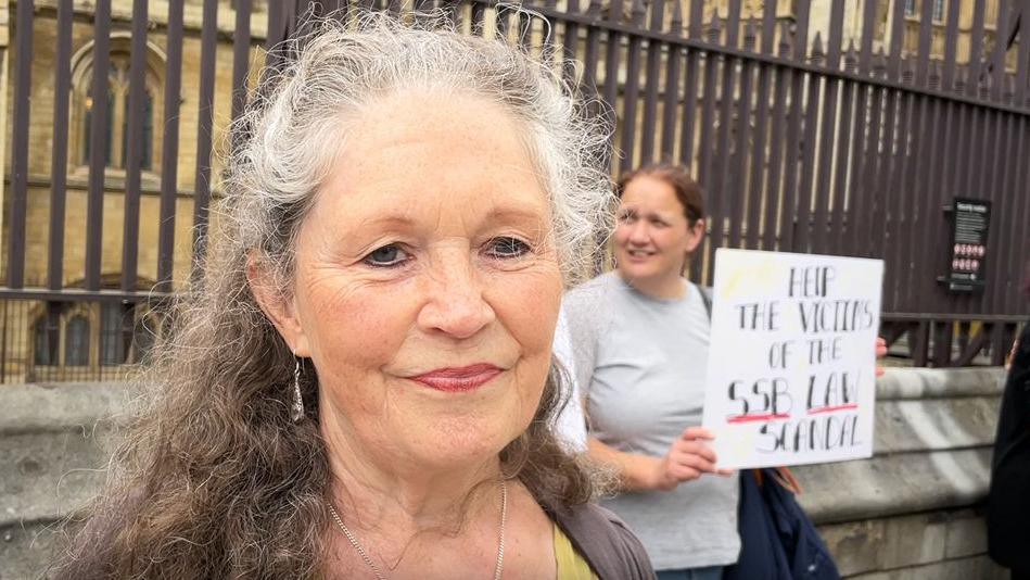 Campaigner Debra Sofia Magdalene outside The Houses of Parliament with other protesters