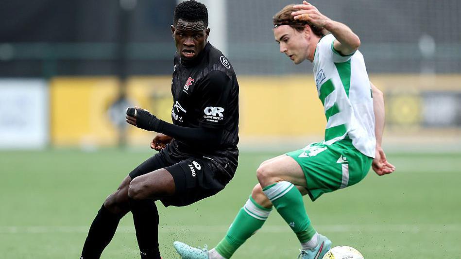 Boris Mfoumou of Differdange battles for possession with Saints' Dan Williams
