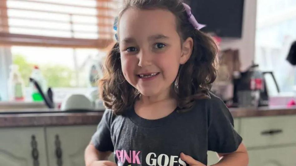 A smiling Bebe King shows off her t-shirt, which has a logo from the Wicked musical, and the caption "pink goes with green"