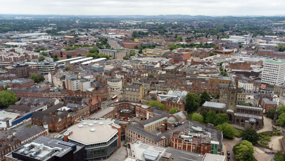 An aerial shot of Wolverhampton. Buildings, roads and trees are visible.