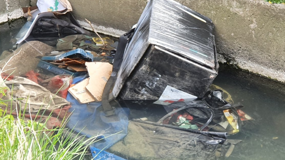 A close-up of mounds of rubbish in the water course. 