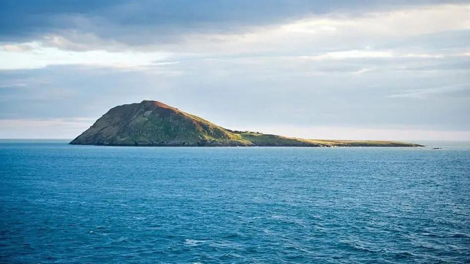 A rocky islet sits in the middle of the sea.