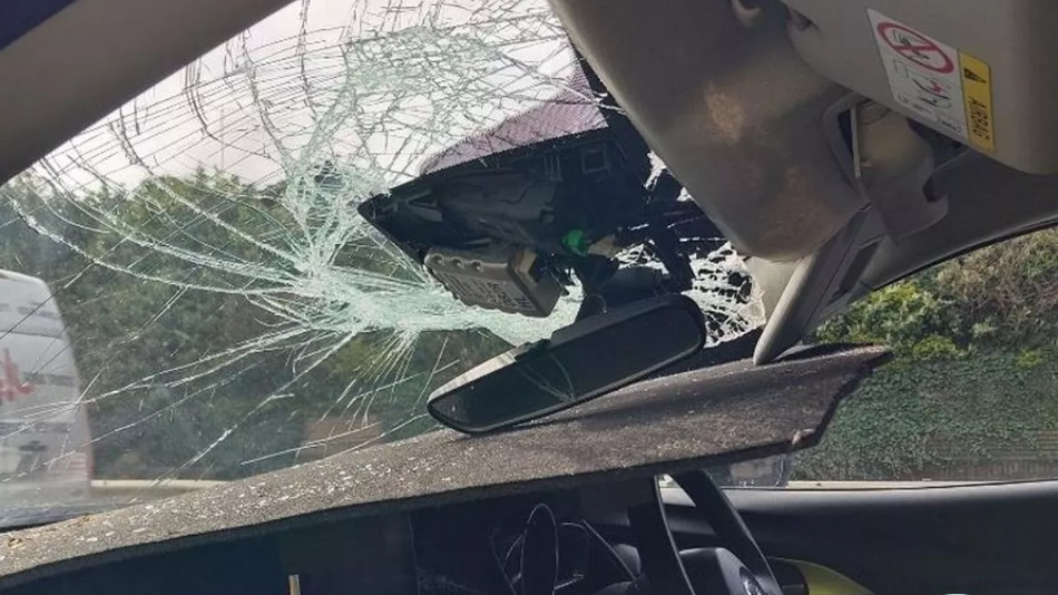 Drain cover impaled through a smashed car windscreen