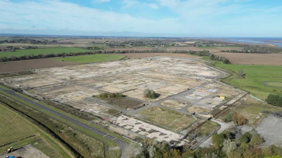 An aerial photograph of the Theddlethorpe site, a former industrial site surrounded by fields. The sea can see seen in the background.