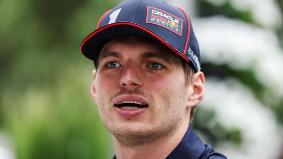 A close-up image of Max Verstappen wearing a Red Bull Racing cap