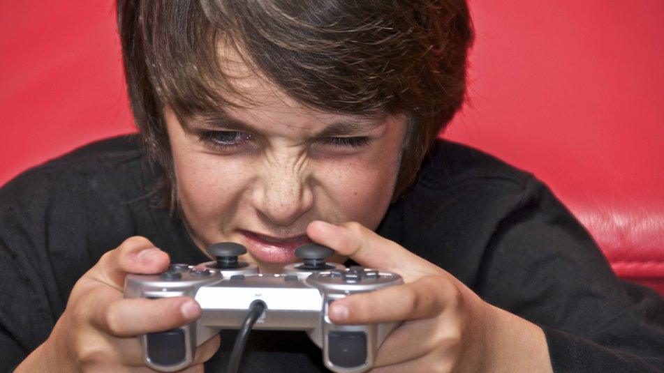 Image of a child concentrating with a games controller in his hand