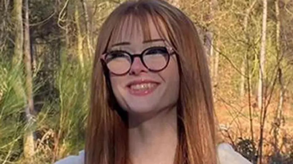 Undated family handout file photo issued by Cheshire Police of Brianna Ghey with long auburn hair and black glasses wearing a cream cardigan in a park. She is smiling.