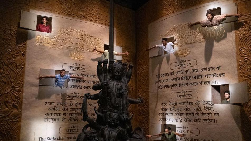 At one of the pandals, the idol stands before the Constitution, with windows illustrating scenes that spark dialogue on social issues